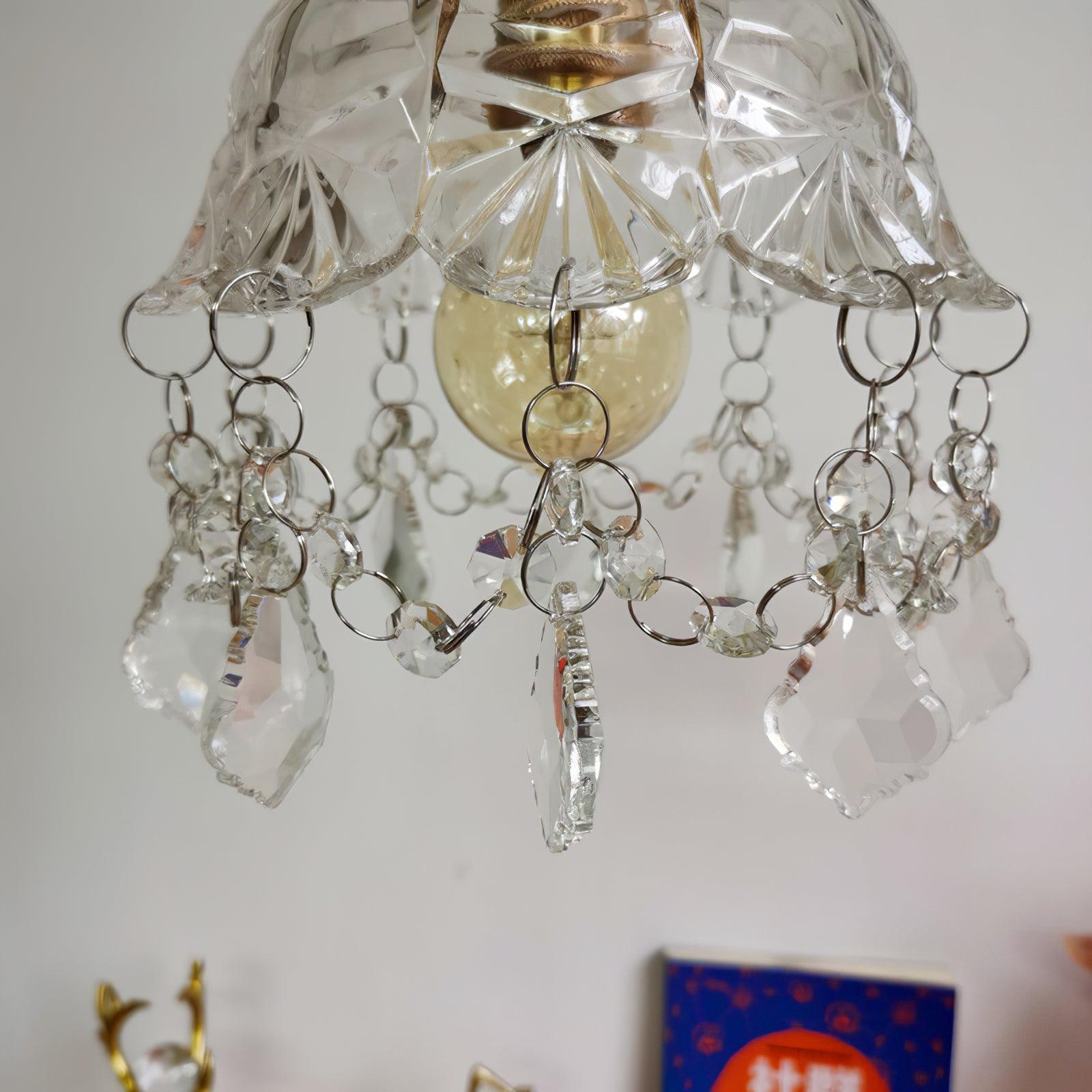 Unlit bulb beneath the patterned bell shade, surrounded by loop-linked bead garlands and clear drops