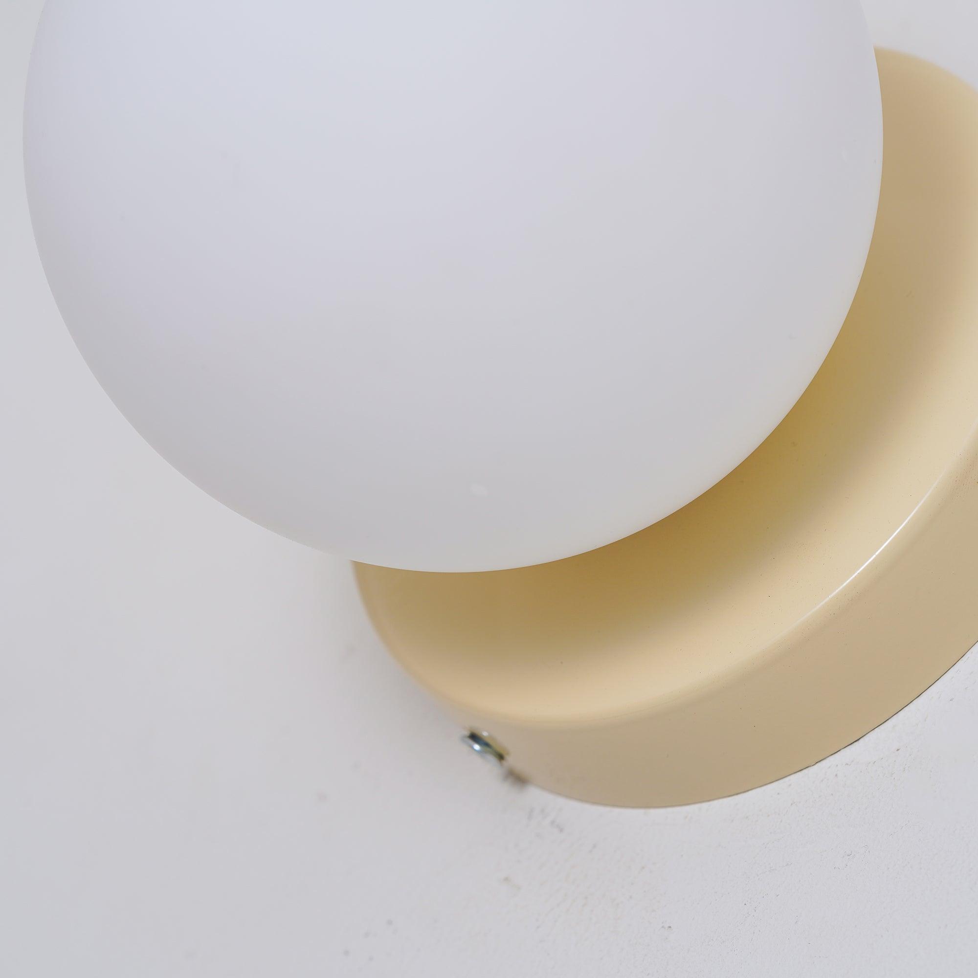 White glass globe and beige plate with an edge screw