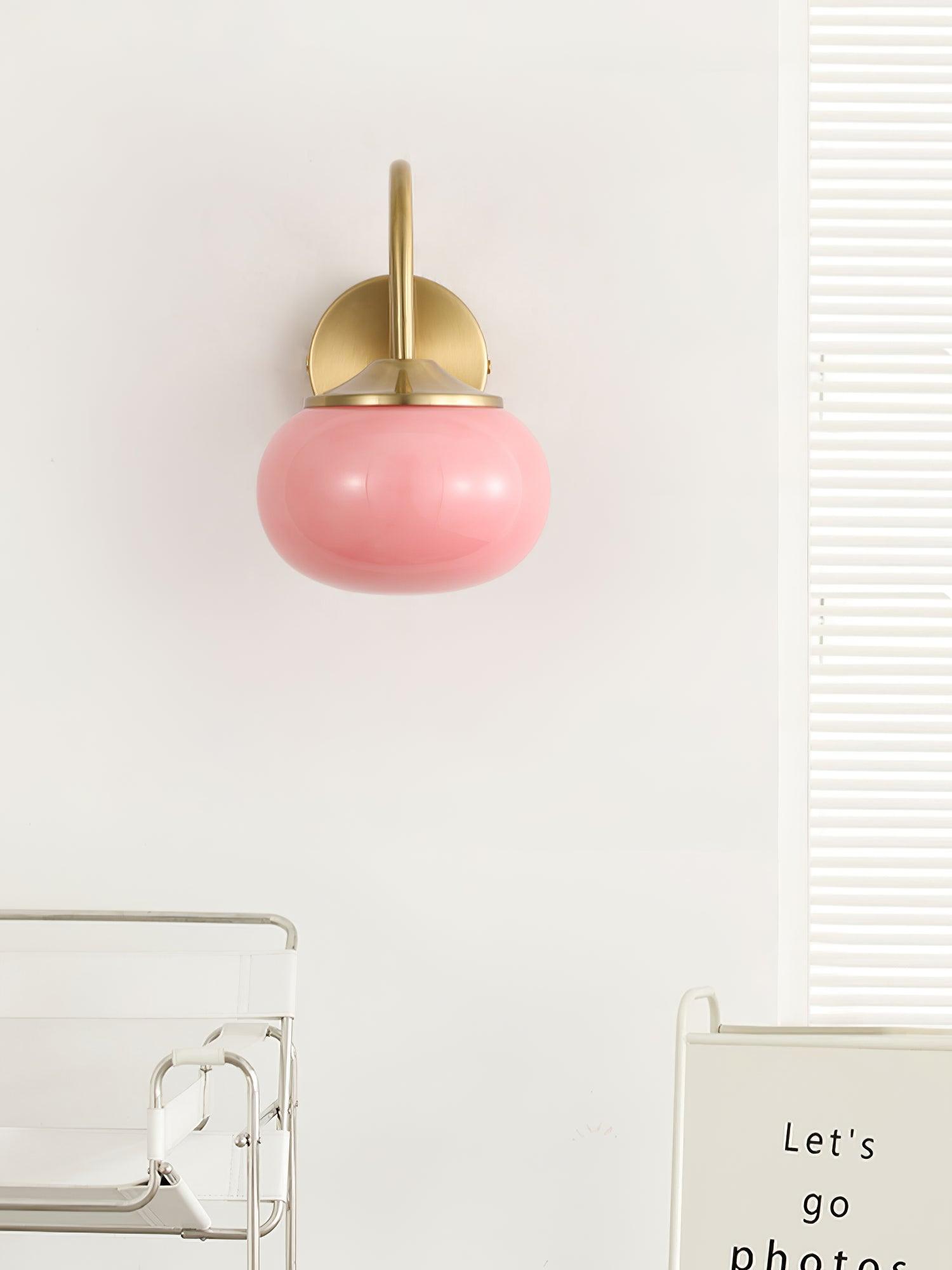 Pink wall light viewed beneath its curved arm