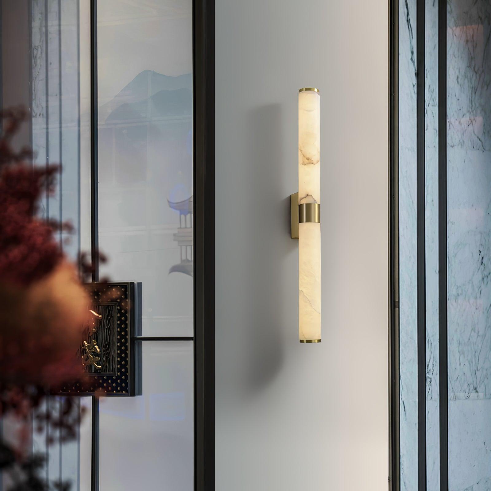 Linear alabaster wall light beside dark door trim