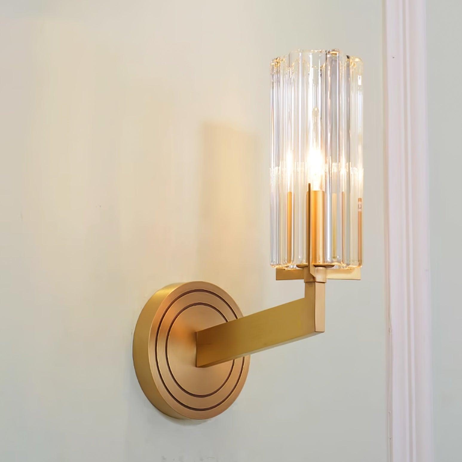 Single-shade Kayla lit on pale wall beside moulding, with clear fluted glass, rectangular brass arm and ringed plate