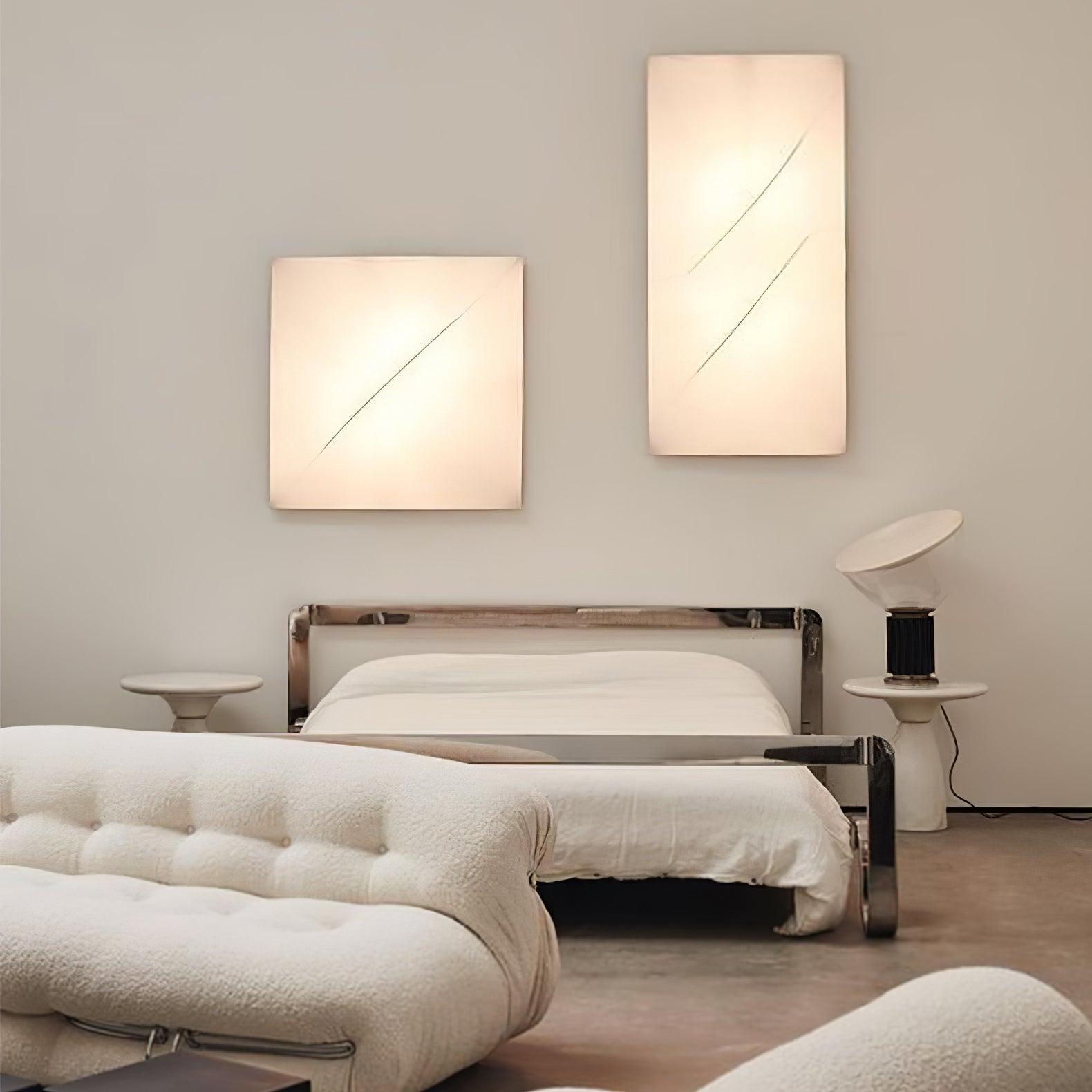 Wide bedroom view with illuminated square and rectangular fabric panels above a chrome-framed bed
