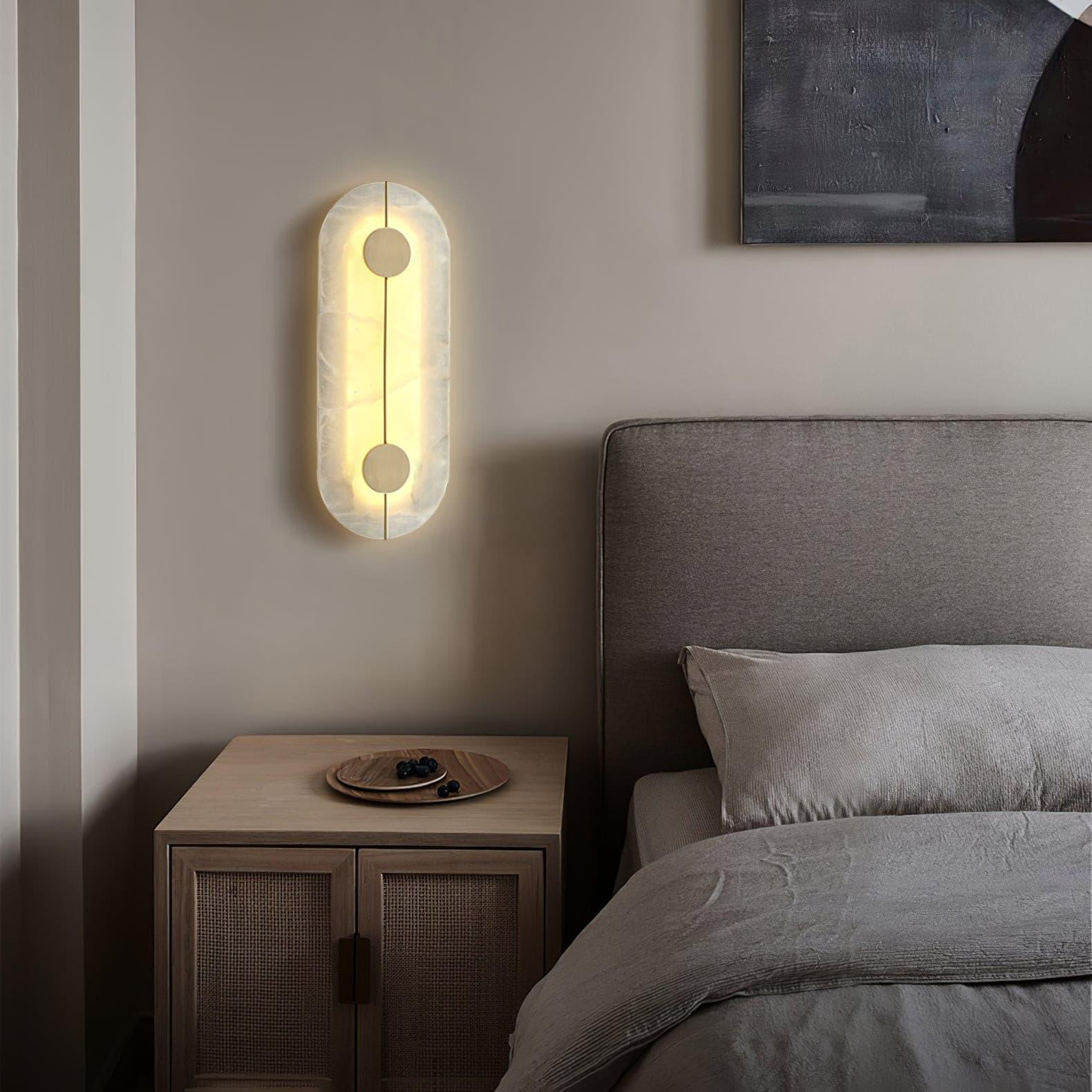 Capsule wall light beside a bedside telephone
