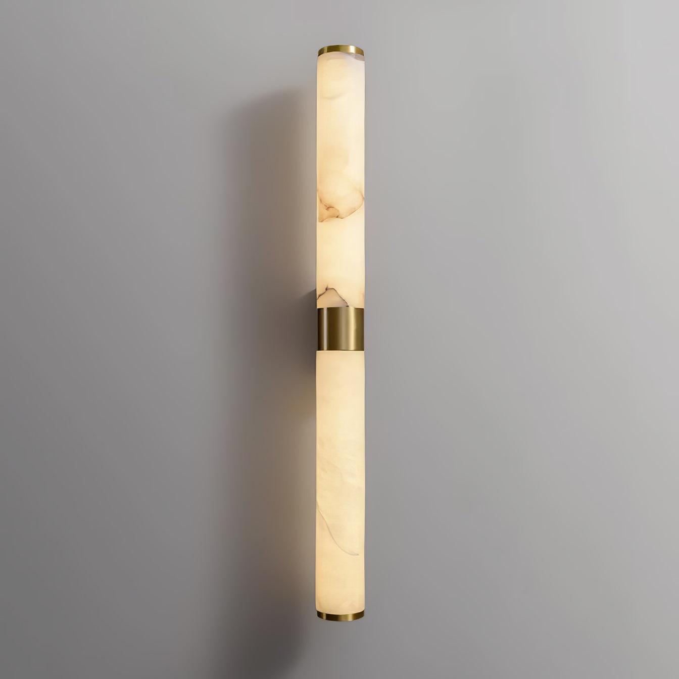 Veined alabaster tube illuminated against a grey wall