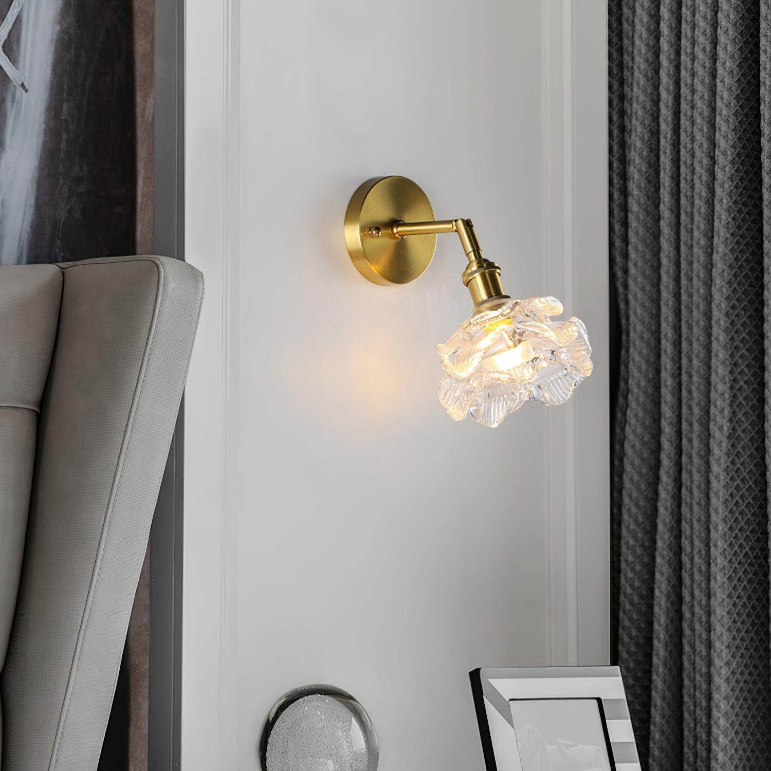 Downward-angled glass wall lamp beside a grey chair