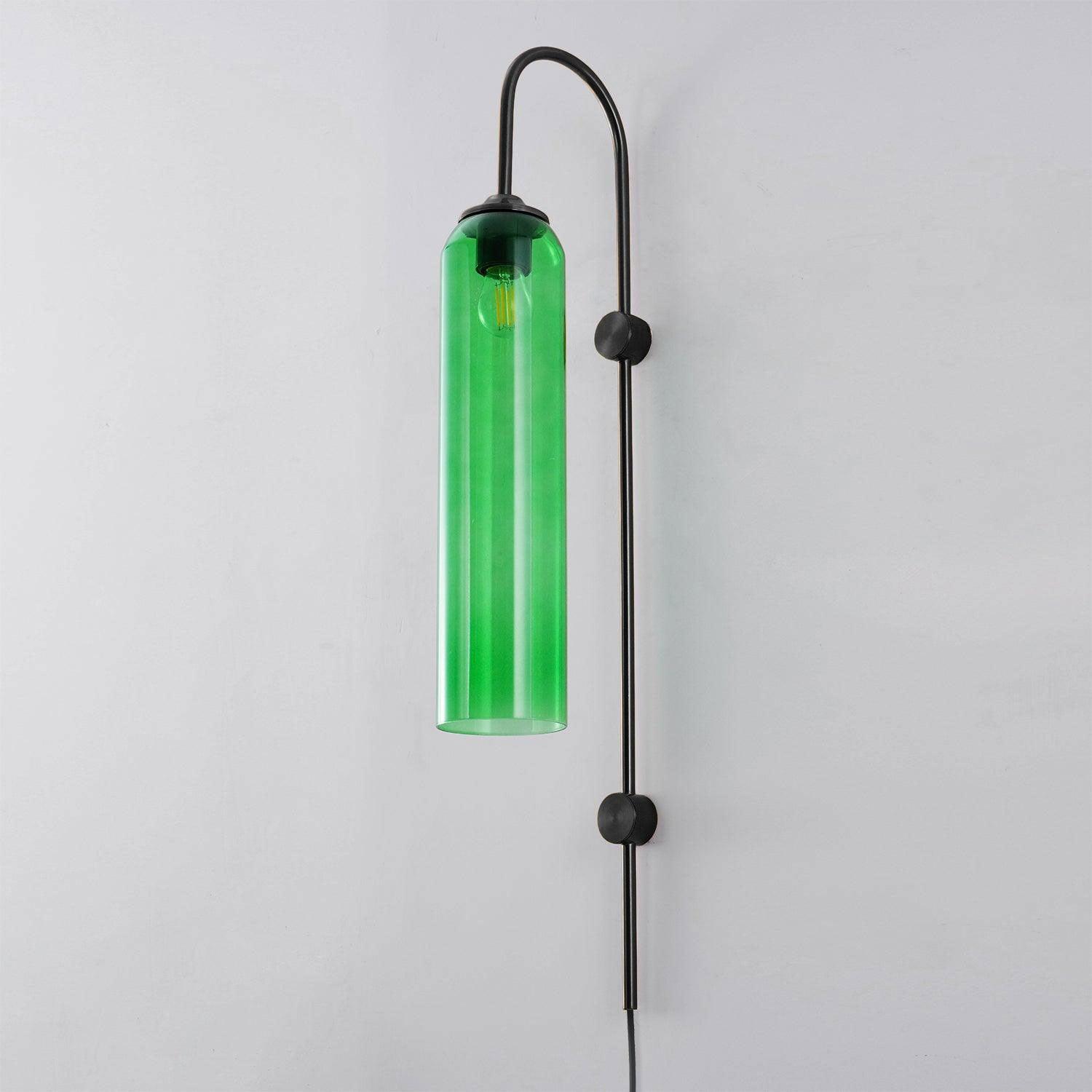 Green cylindrical glass shade on a black wall frame