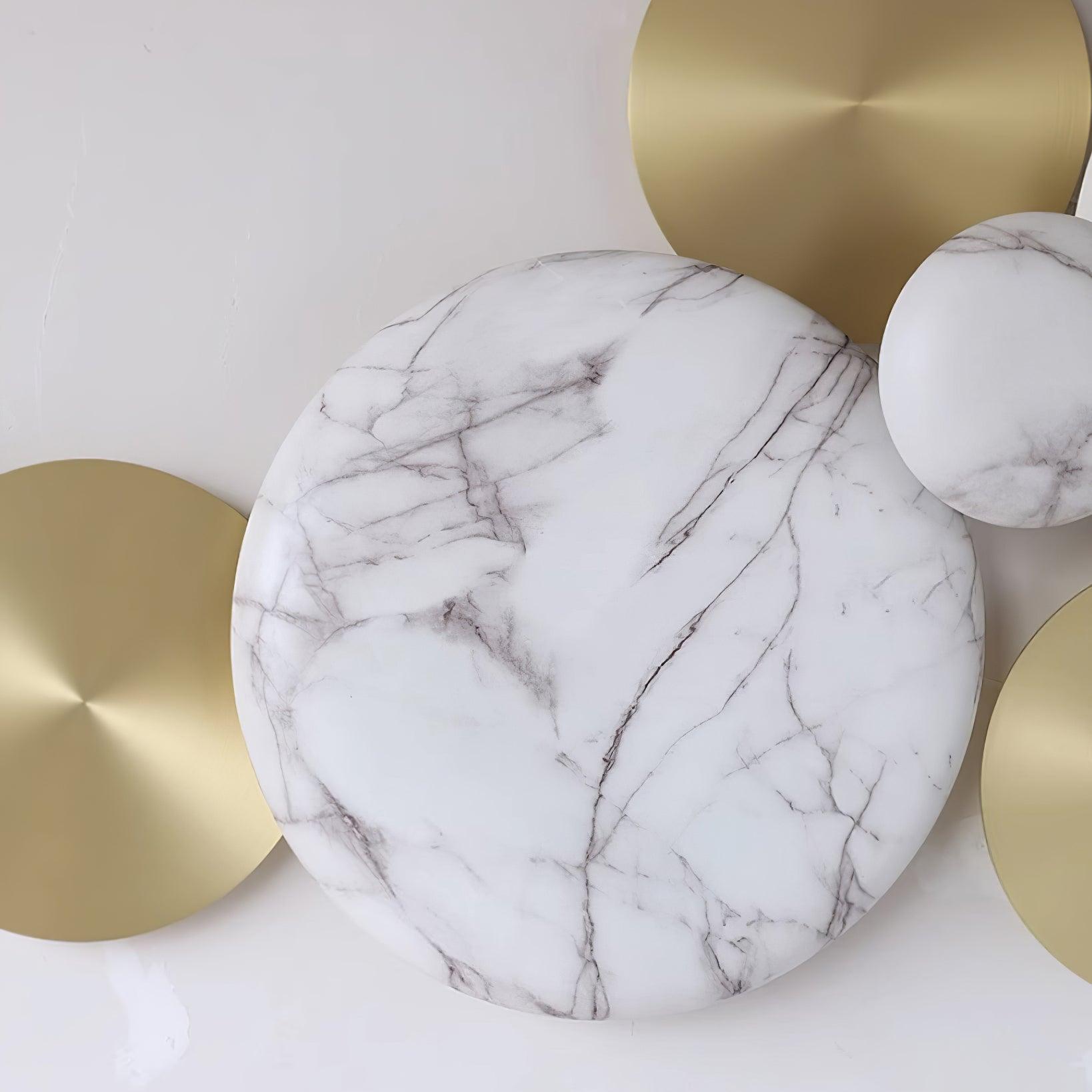 Close-up of gray veining across a white circular face beside flat gold-tone discs