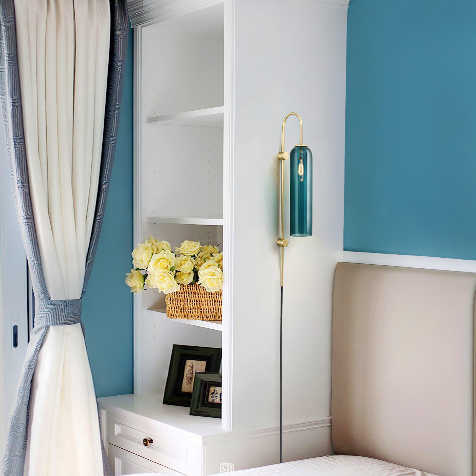 Glass tube lamp above a small bedside unit
