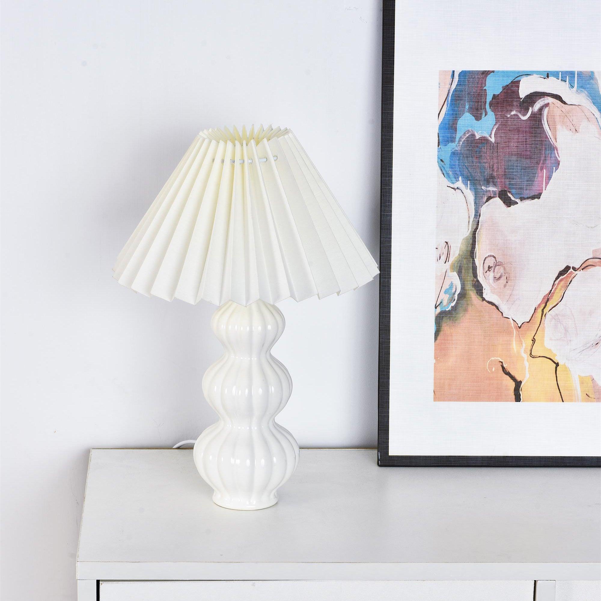 Leo lamp on a cabinet beside framed portrait artwork