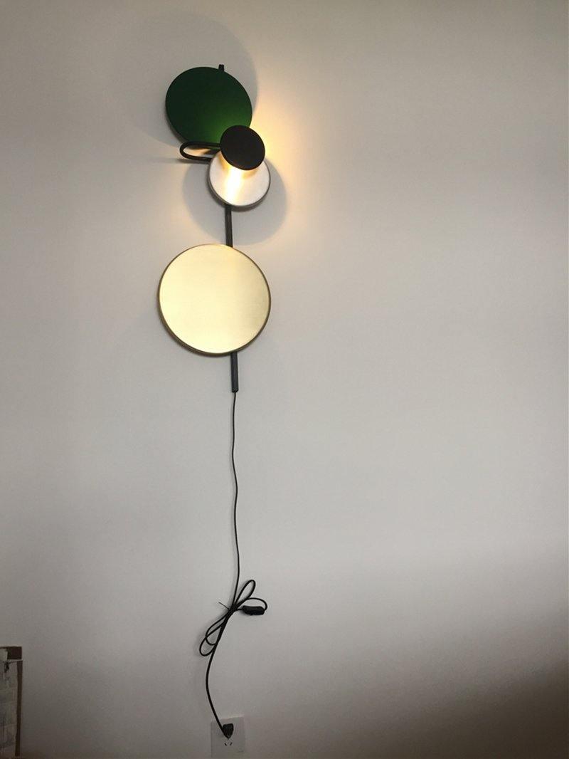 Disc wall light pictured with a hanging power cord