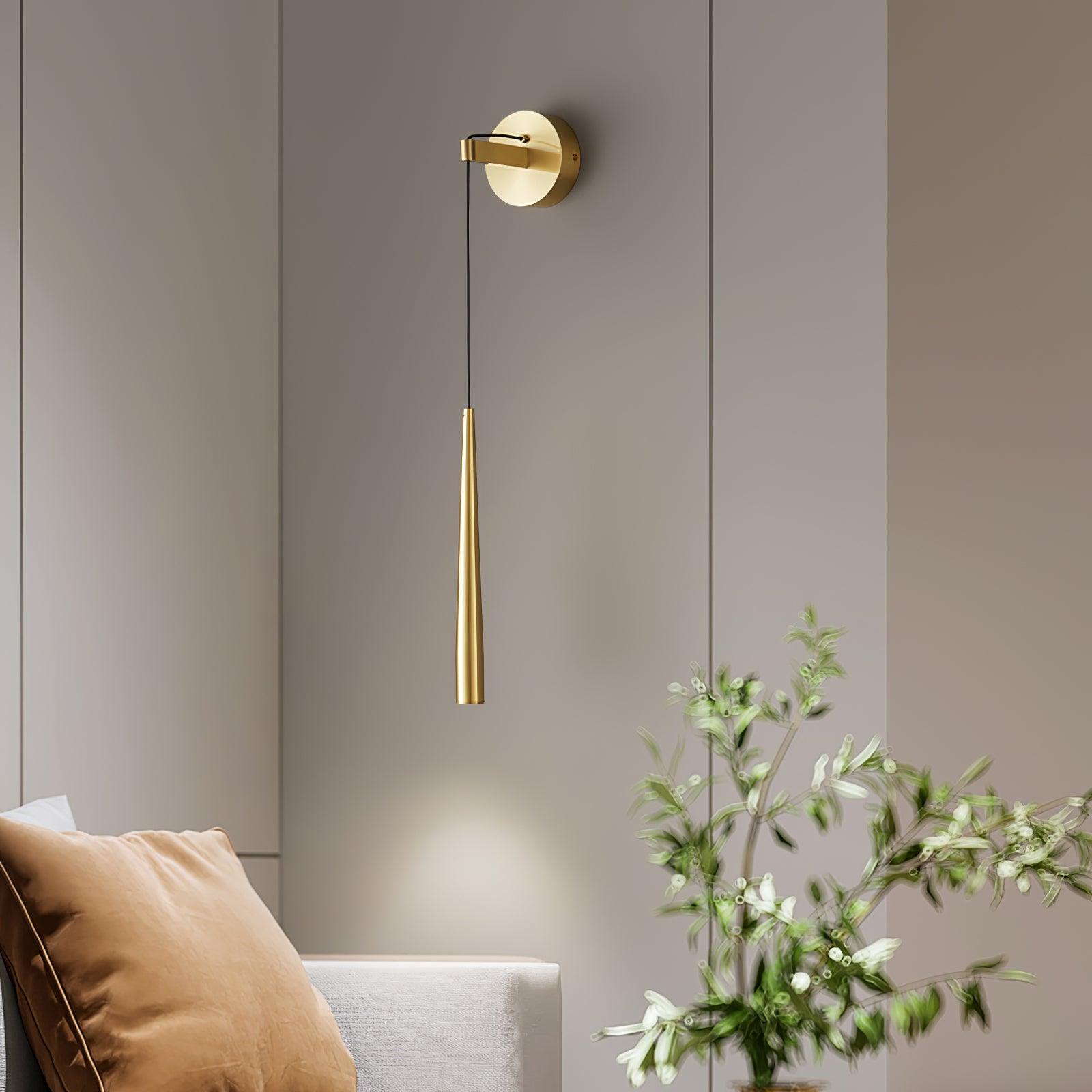 Plain-ended brass-tone cone hanging beside a sofa and leafy branches on a paneled wall