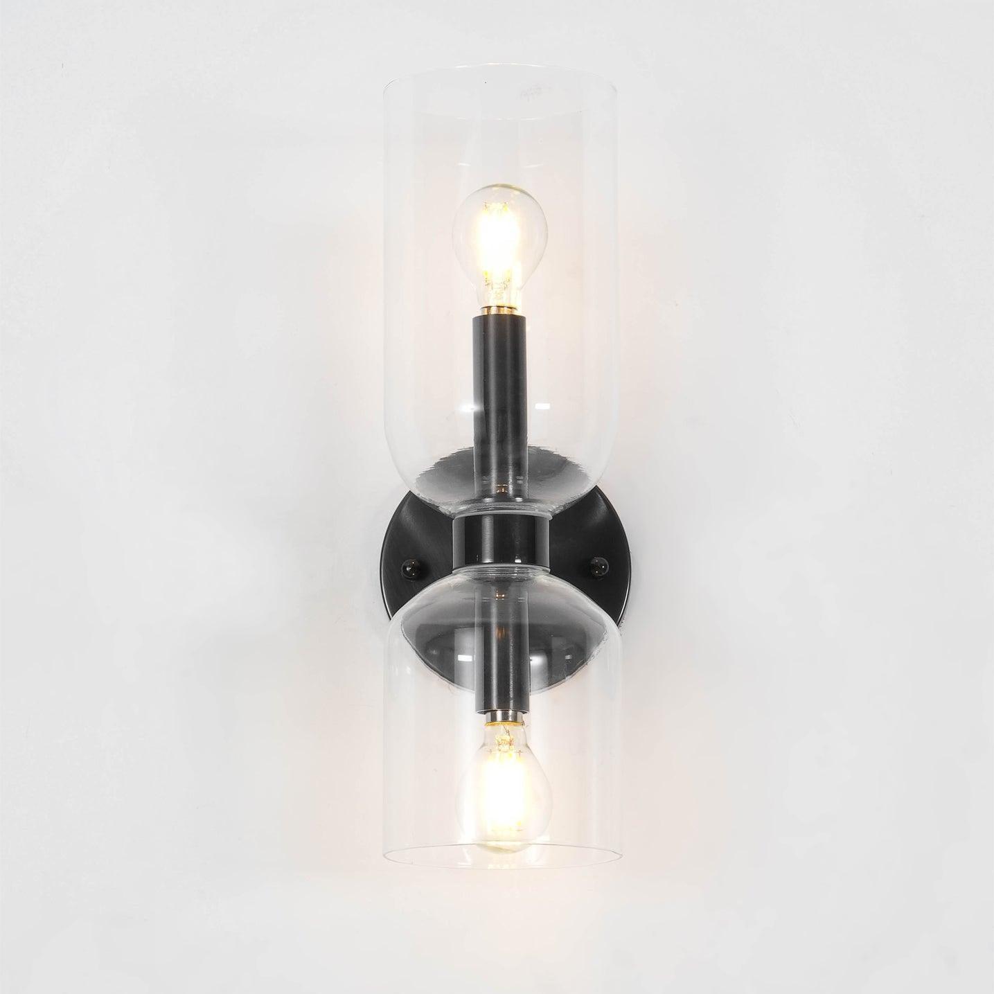 Clear glass wall light with black fitting and upper and lower bulbs