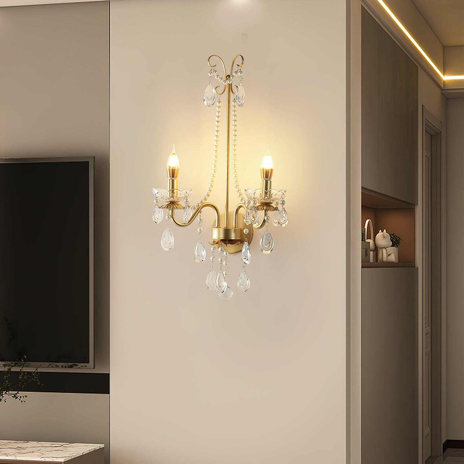 Lit two-arm bead-chain wall light beside dark TV and hallway doorway with recessed shelf, ornament and ceiling strip lighting