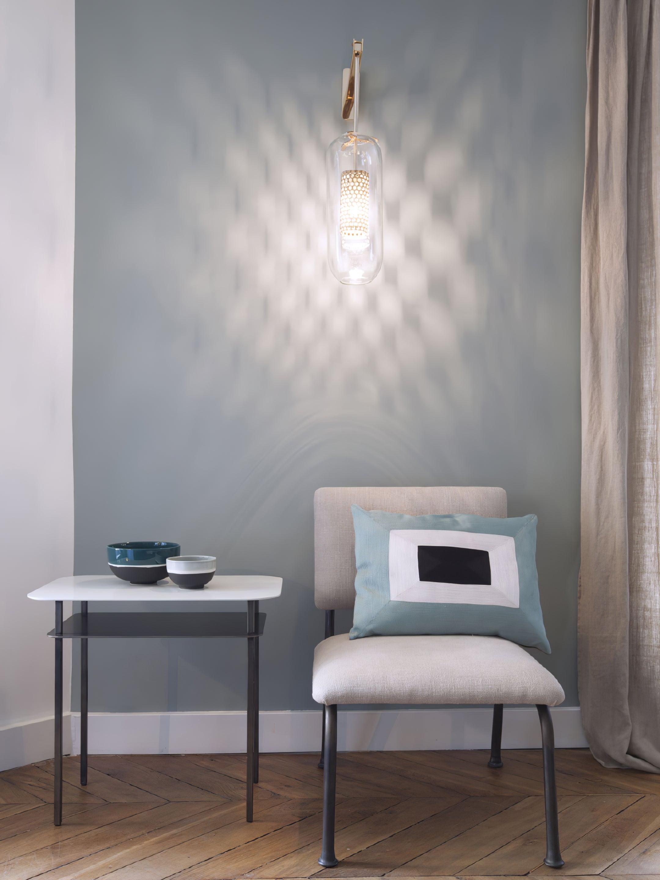 Lit glass sconce projecting a patterned glow