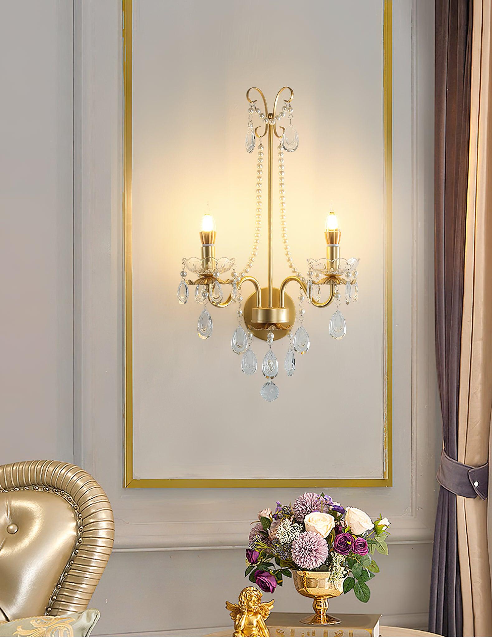 Wider lit fixture in gold-bordered panel beside curtain, with gold chair, colourful flowers in gold vase and cherub ornament below