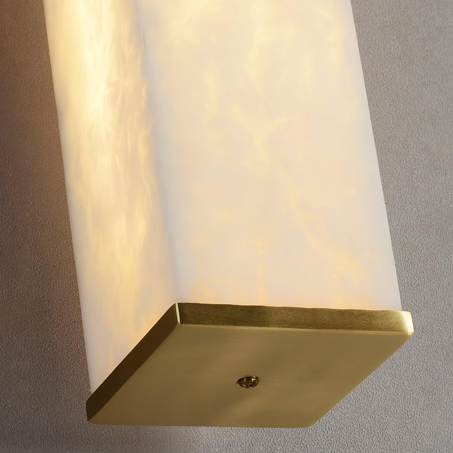 Close underside view of a flat brass-colored end plate with a central screw beneath the glowing veined stone cover