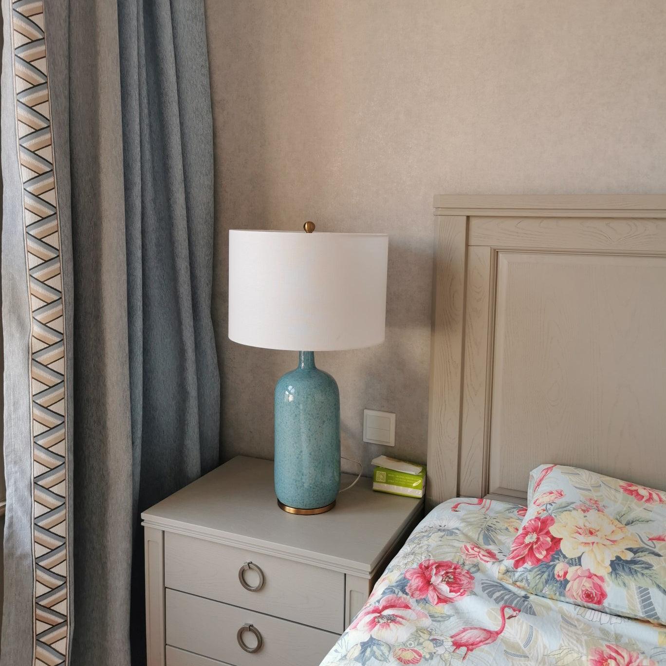 Culloden blue lamp beside a bed with floral bedding