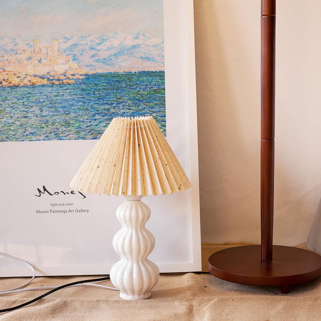 Leo lamp with a pale tan flecked shade beside framed landscape art