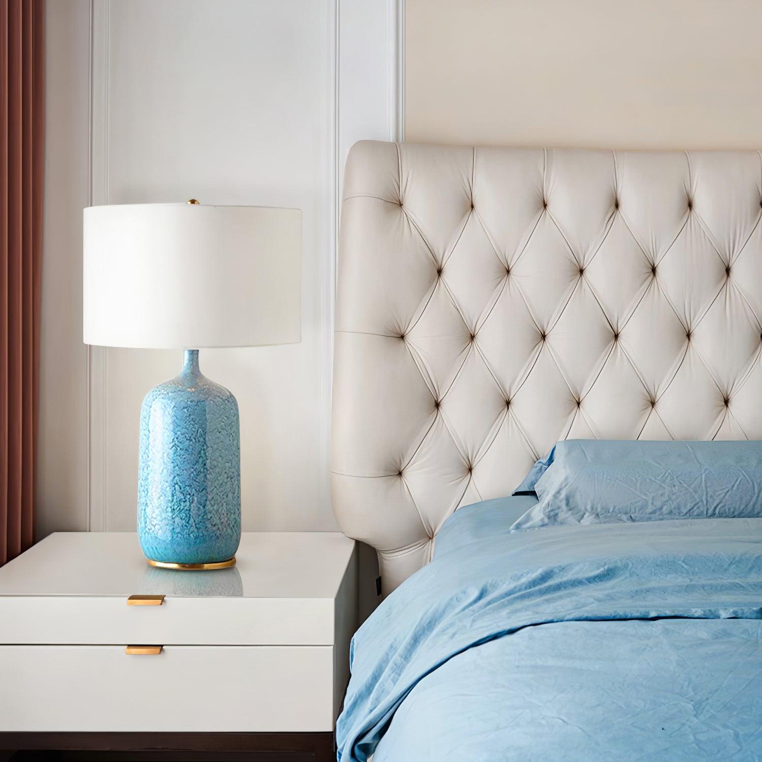 Culloden table lamp beside a white tufted headboard
