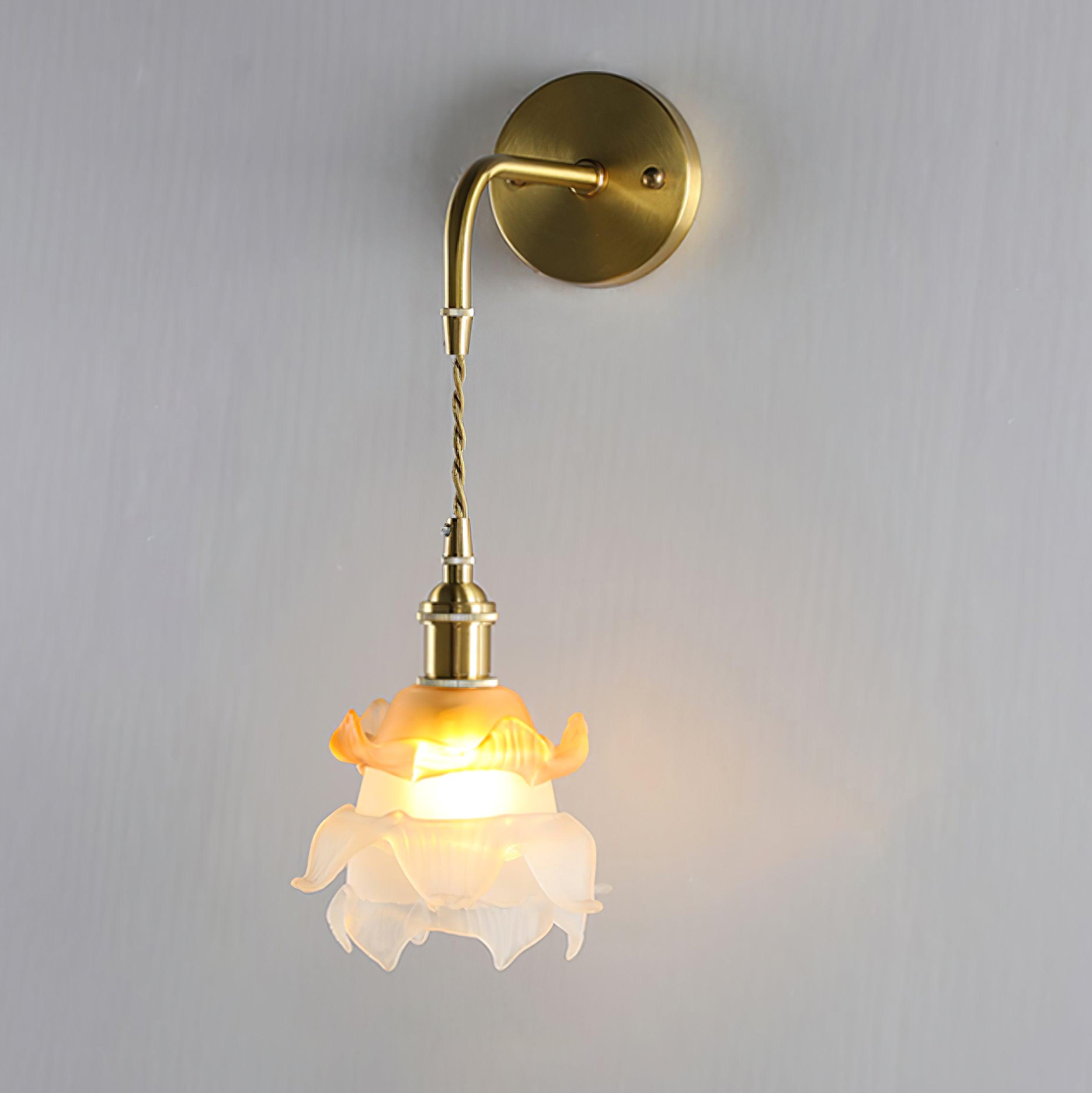 Layered petal-like glass shade suspended from a curved brass wall arm