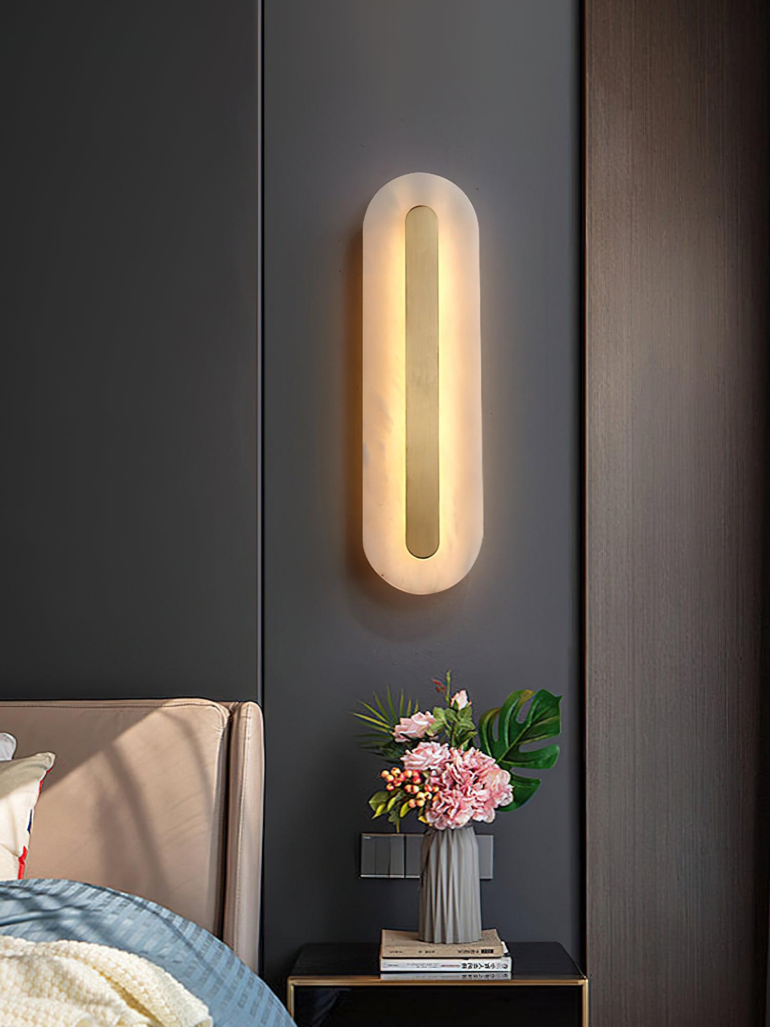 Rounded light above a bedside flower arrangement