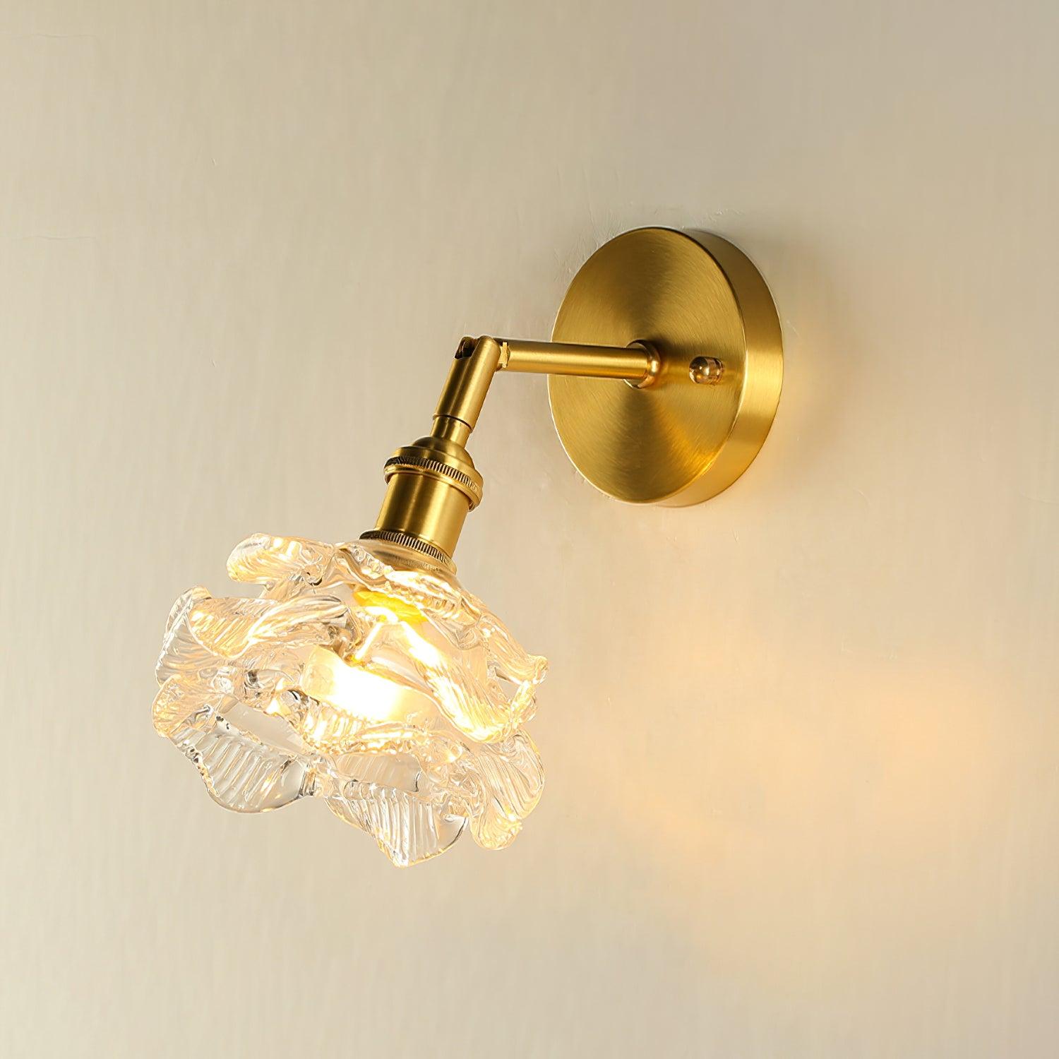 Brass wall lamp with a glowing ruffled glass shade