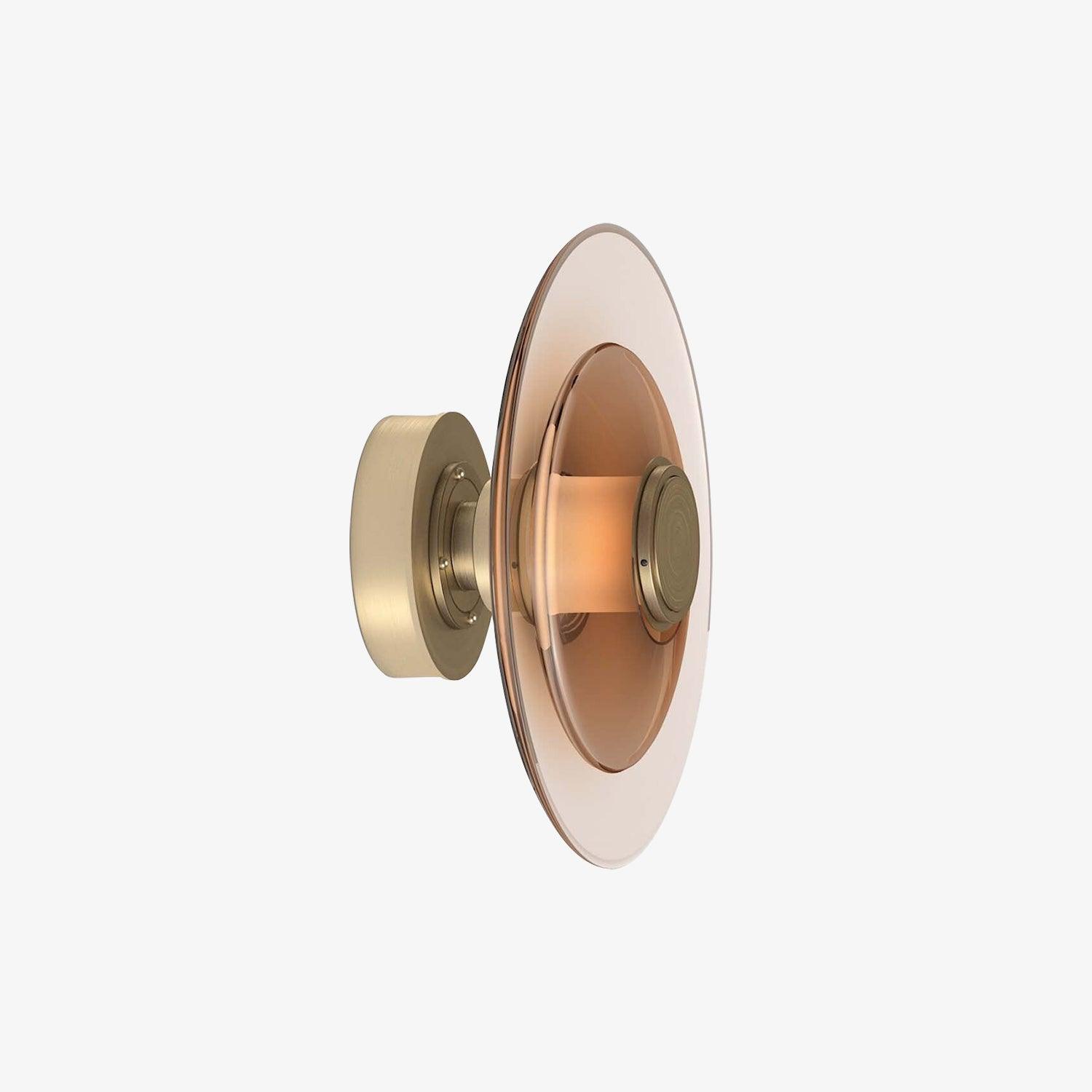 Angled Gold Luna A glass disc sconce on white, with round rear plate, translucent centre band and amber-toned layered circles