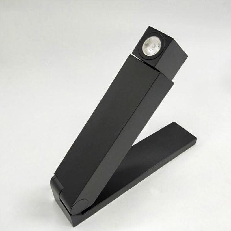 Single black folding wall fixture isolated with opened arm, angular head at upper right and round unlit lens