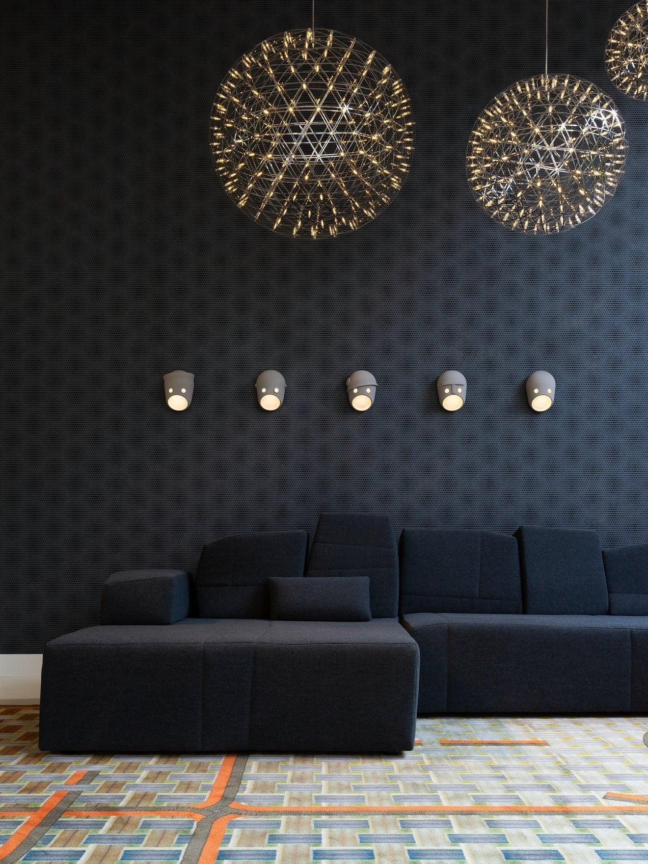 Five face wall lights above a sofa