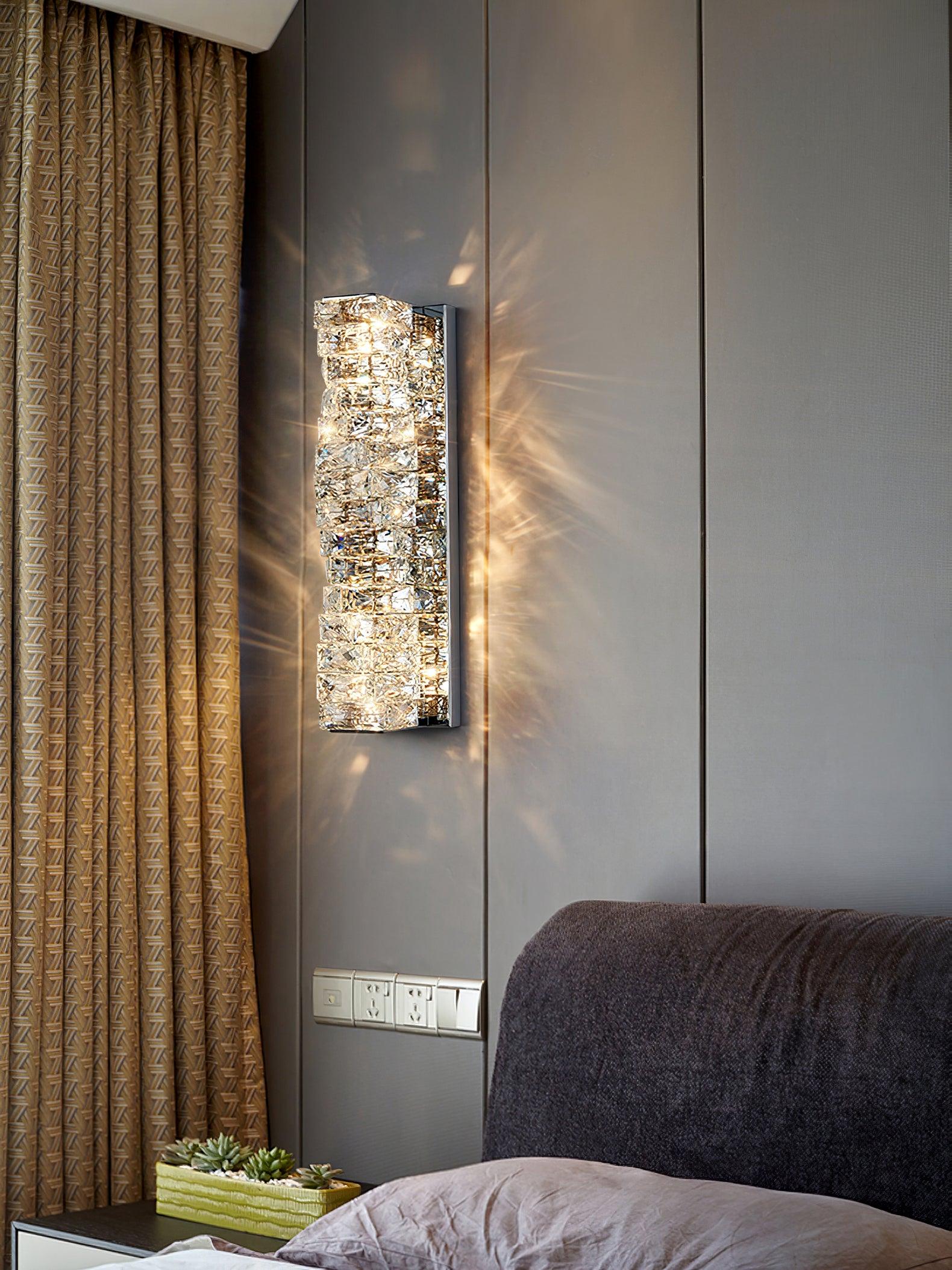 Vertical crystal sconce near a headboard