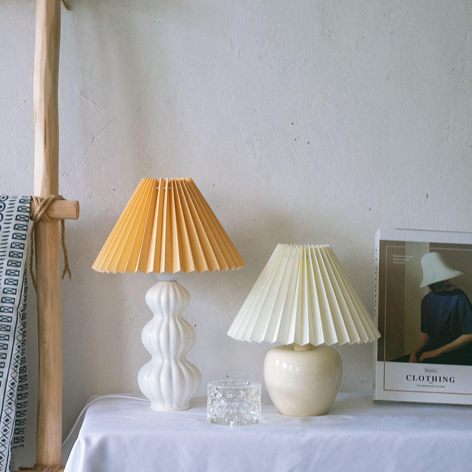 Leo lamp with a pale pleated shade beside a smaller lamp with an ochre shade
