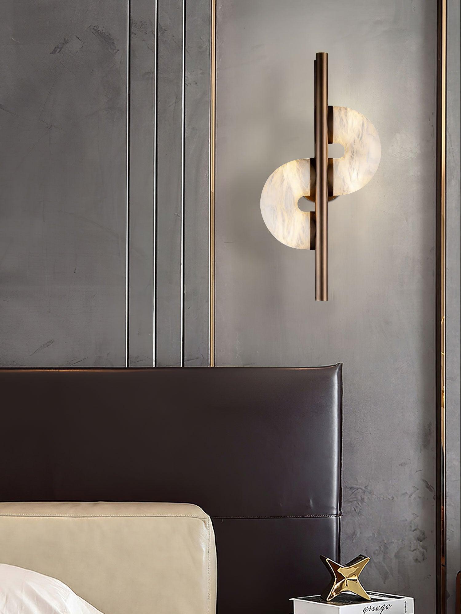 Dolly beside dark leather headboard and cream bedding, above a nightstand with books and gold star ornament