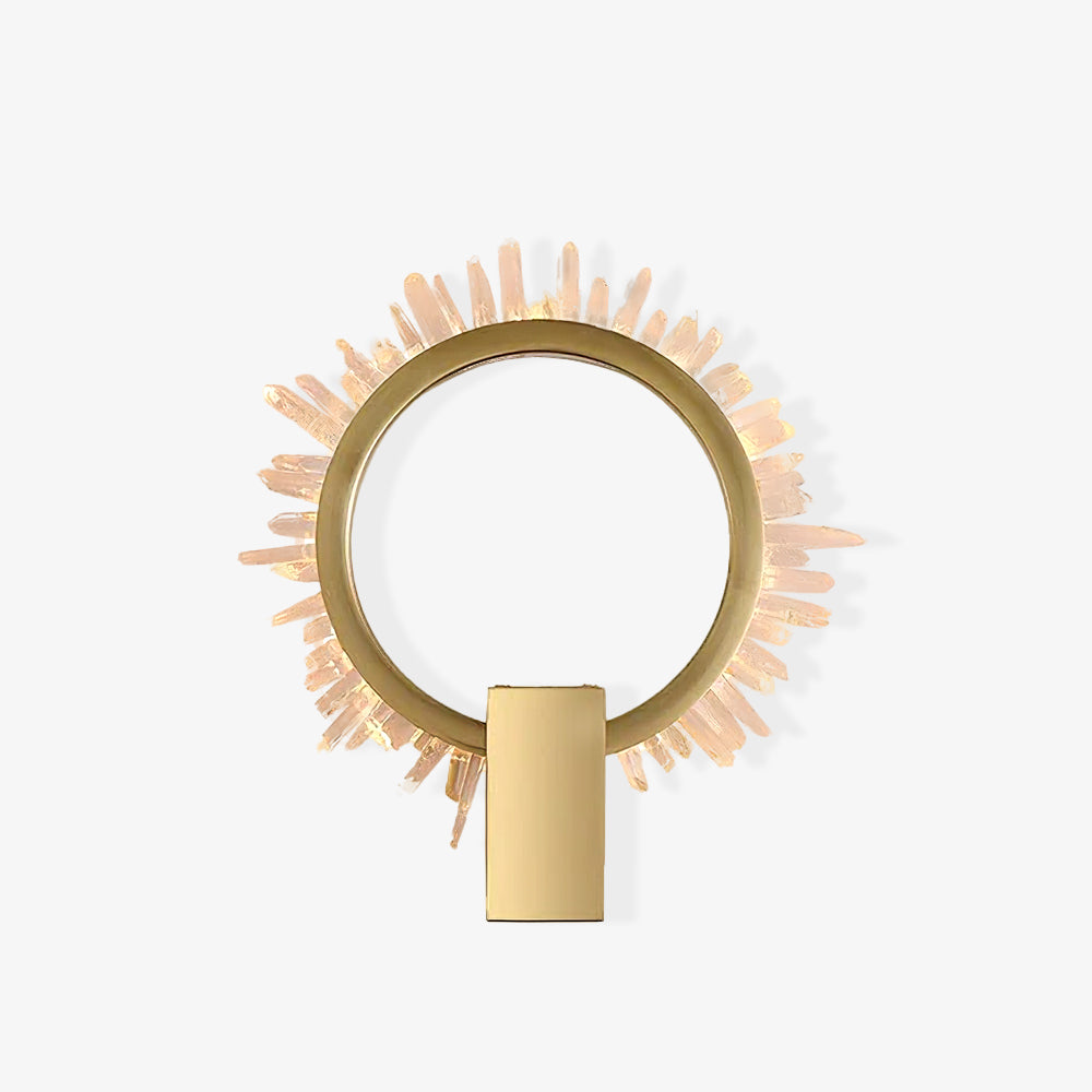 Small isolated gold ring wall lamp with clear crystal points and a rectangular mount on a pale background