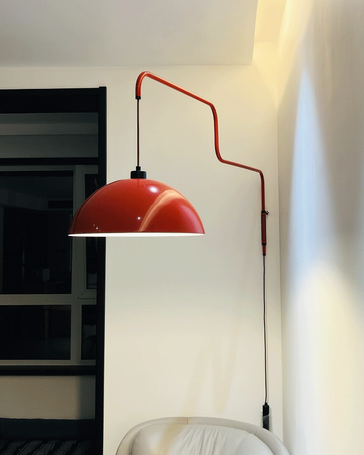 Red hanging shade near a pale wall and chair
