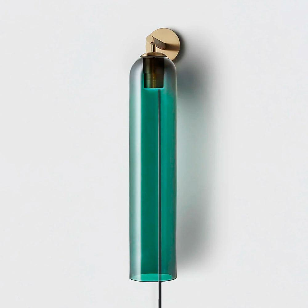 Green glass cylinder on a gold wall light