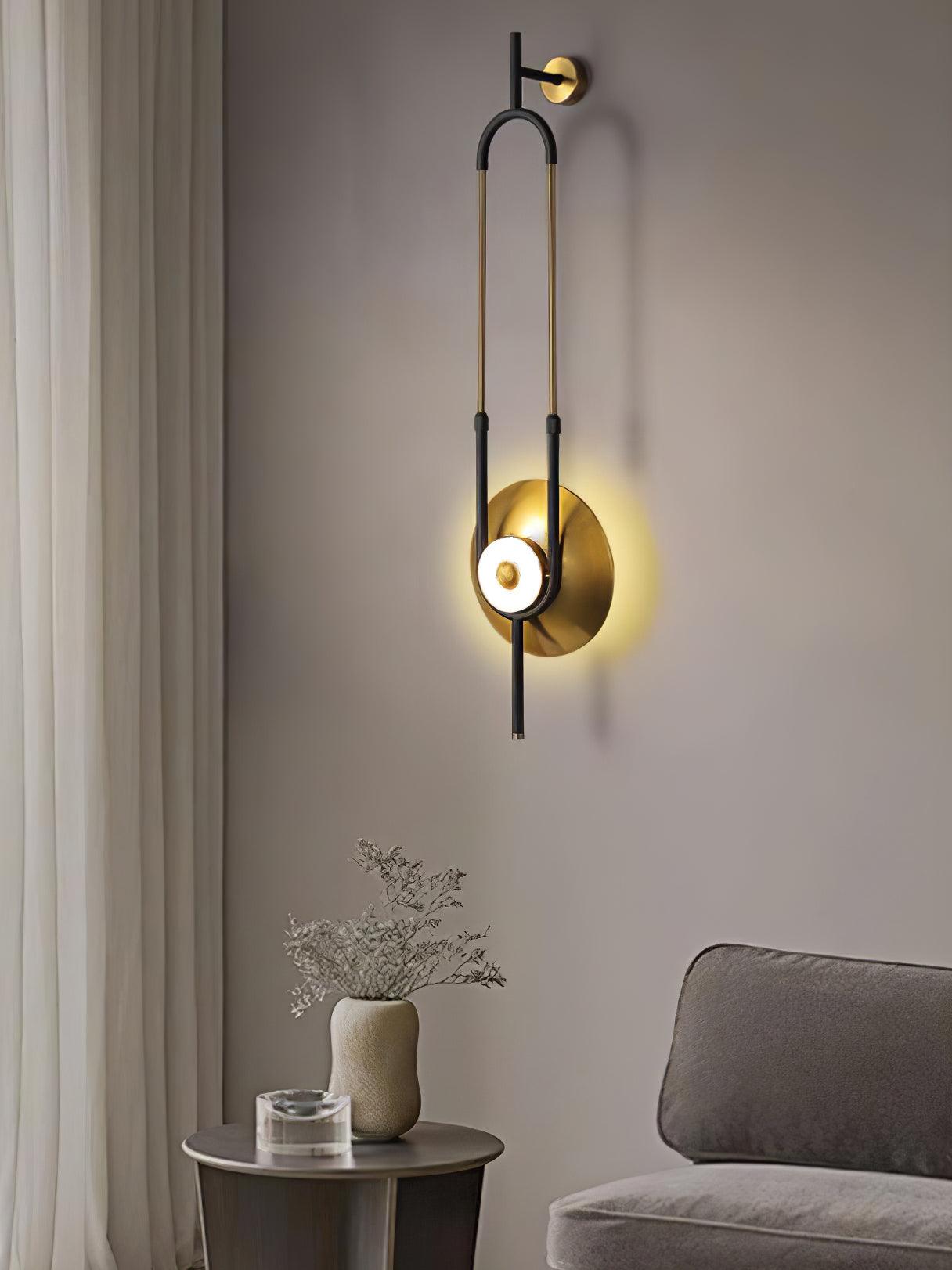 Oblique Ellipse Ring light beside sheer curtains, grey chair and round side table with vase and glass object