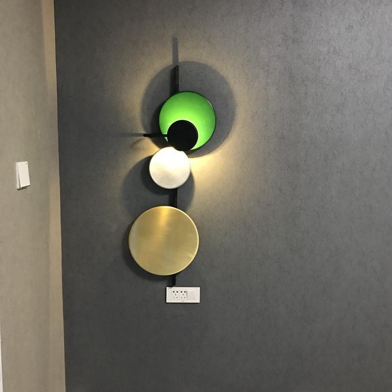 Green disc wall light casting light around its circles
