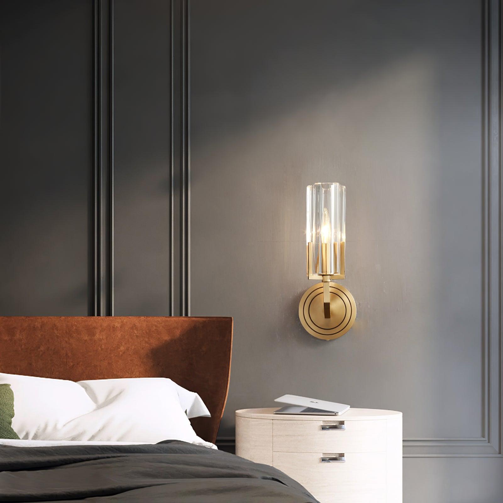 Single clear-glass Kayla above rounded pale bedside drawers with open book beside brown headboard and grey wall panelling