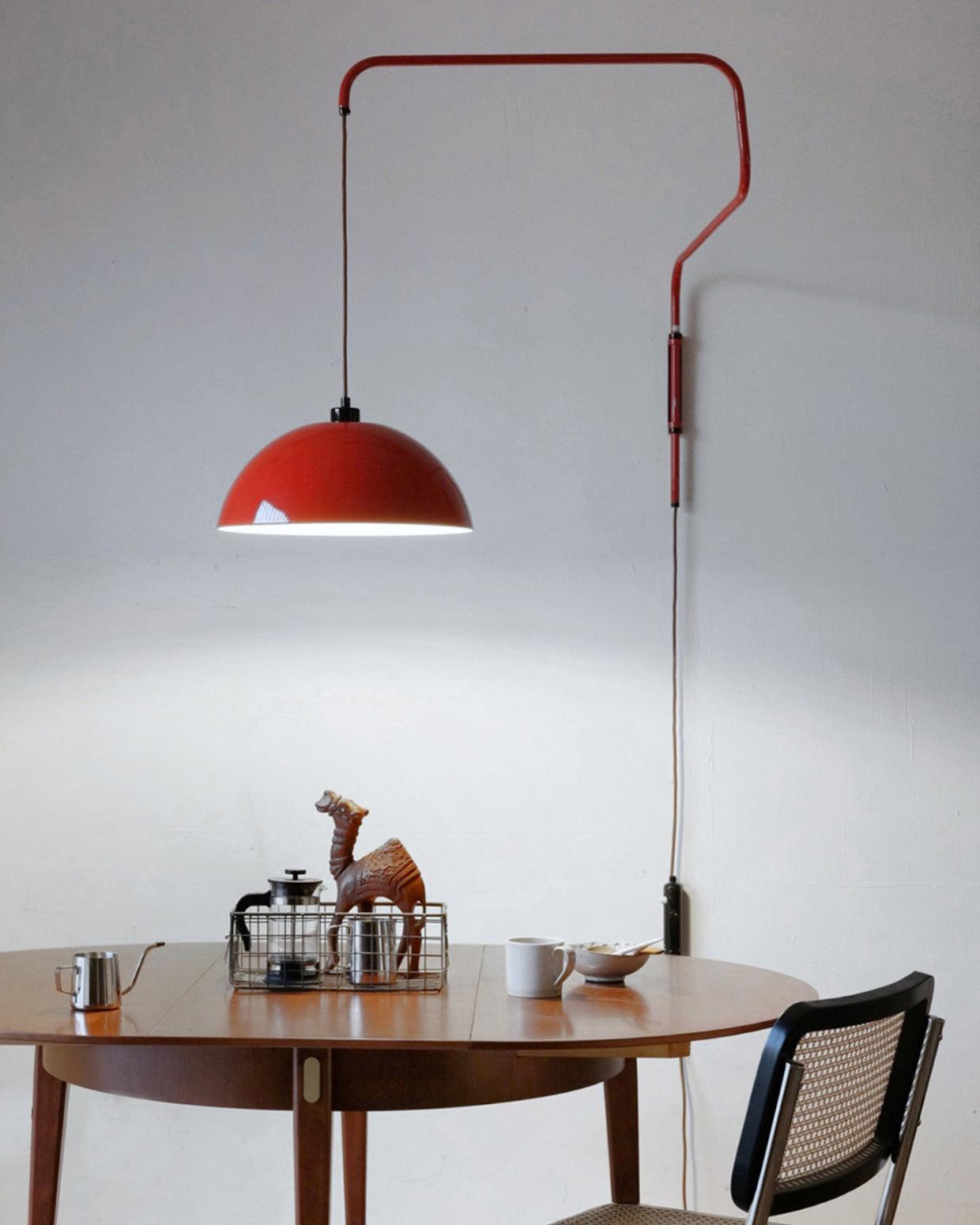 Angular red arm and shade above a round table