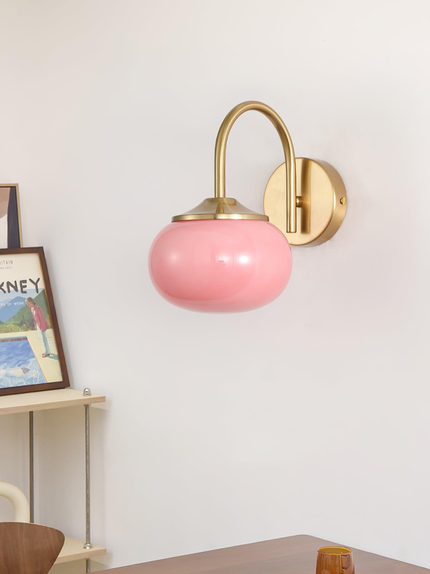 Pink rounded wall light beside a shelf