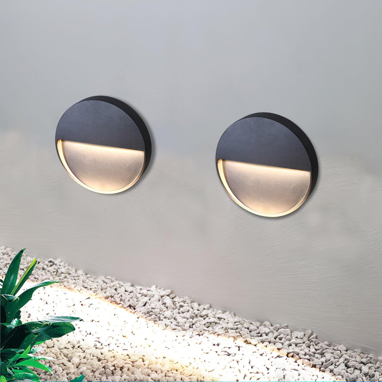Two circular wall lights above gravel planting