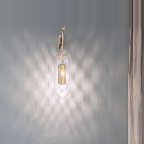 Wall reflections around an illuminated glass sconce