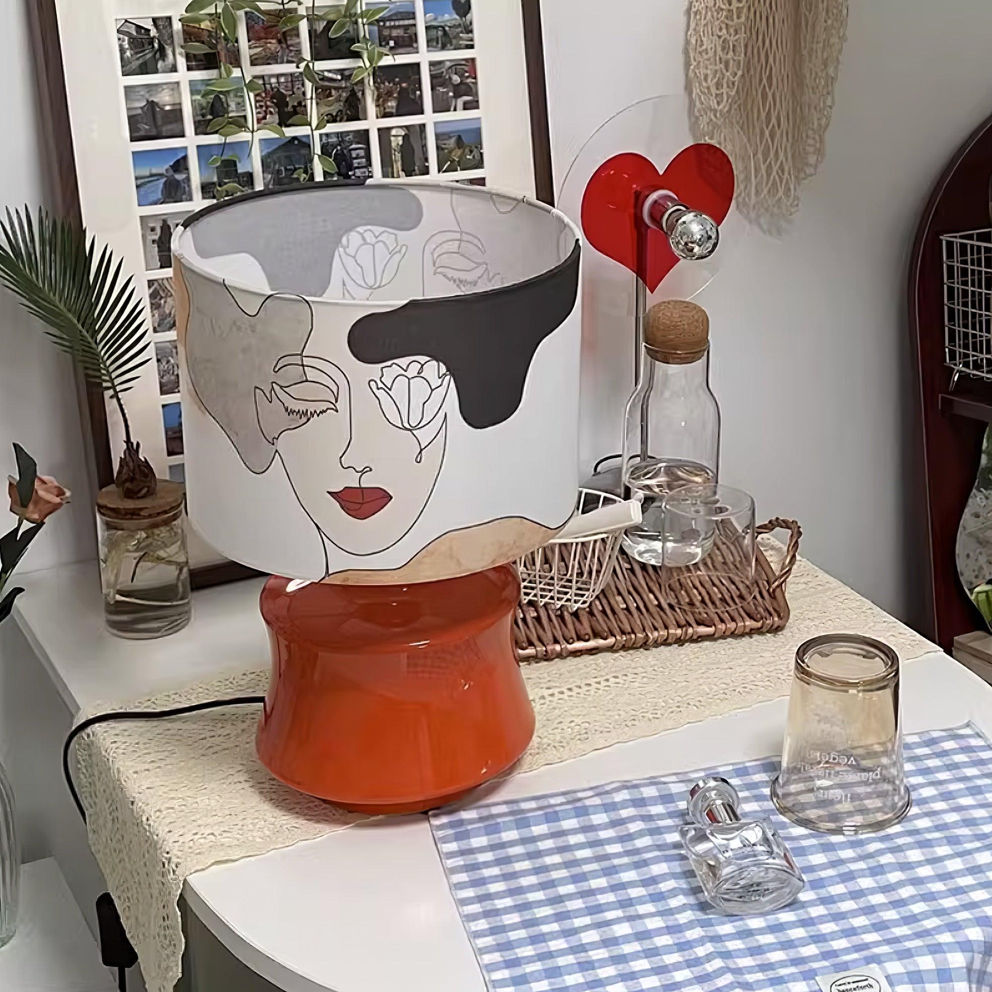 Marilyn lamp on a table showing another section of the face-print shade