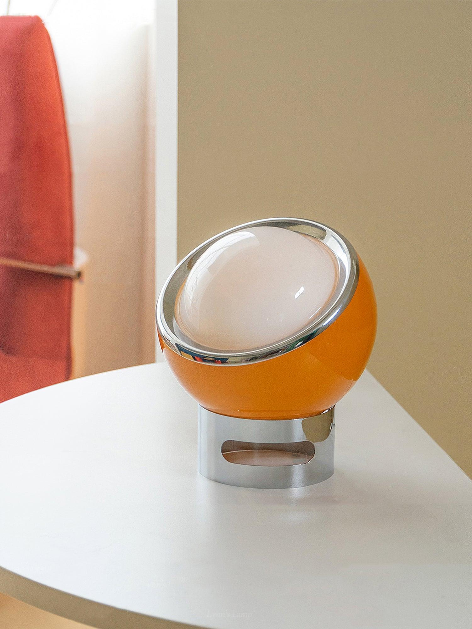 Valeria glass lamp with slanted metallic rim on a white table