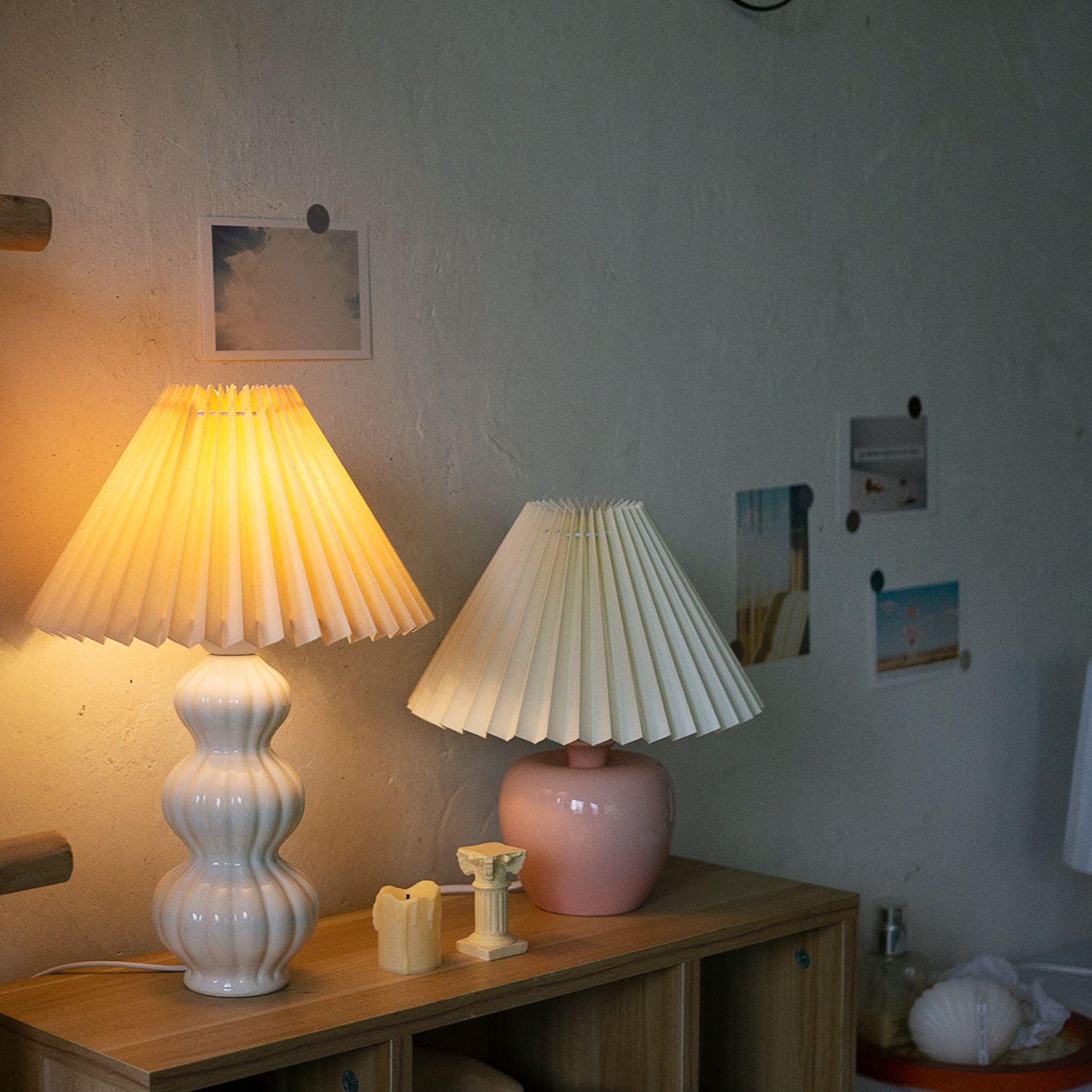 Leo beside candles and a separate pink-base lamp
