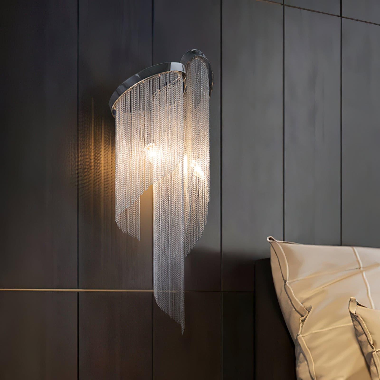 Illuminated Silver chain wall light beside a bed
