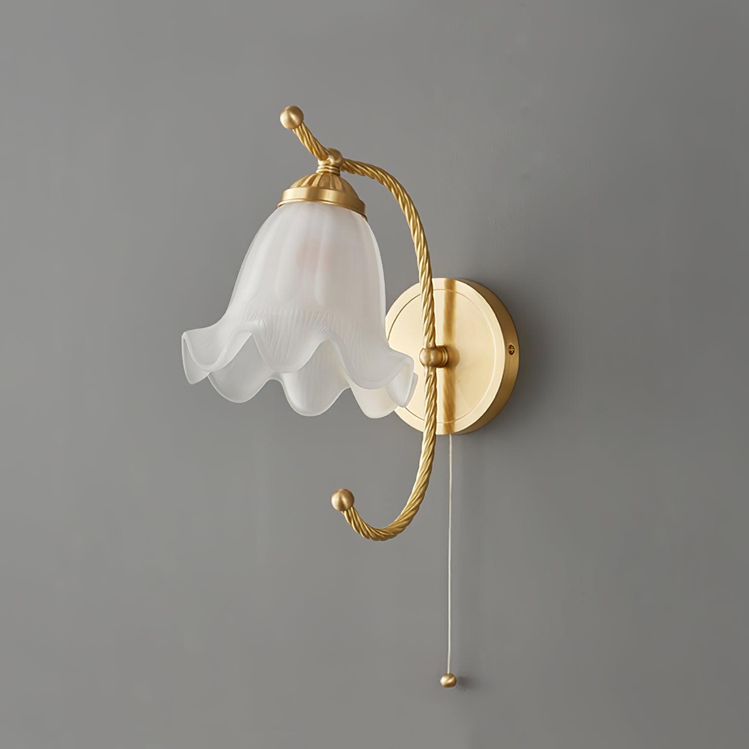 Unlit brass gooseneck wall lamp on grey, showing opaque white scalloped shade, round wallplate and thin pull cord