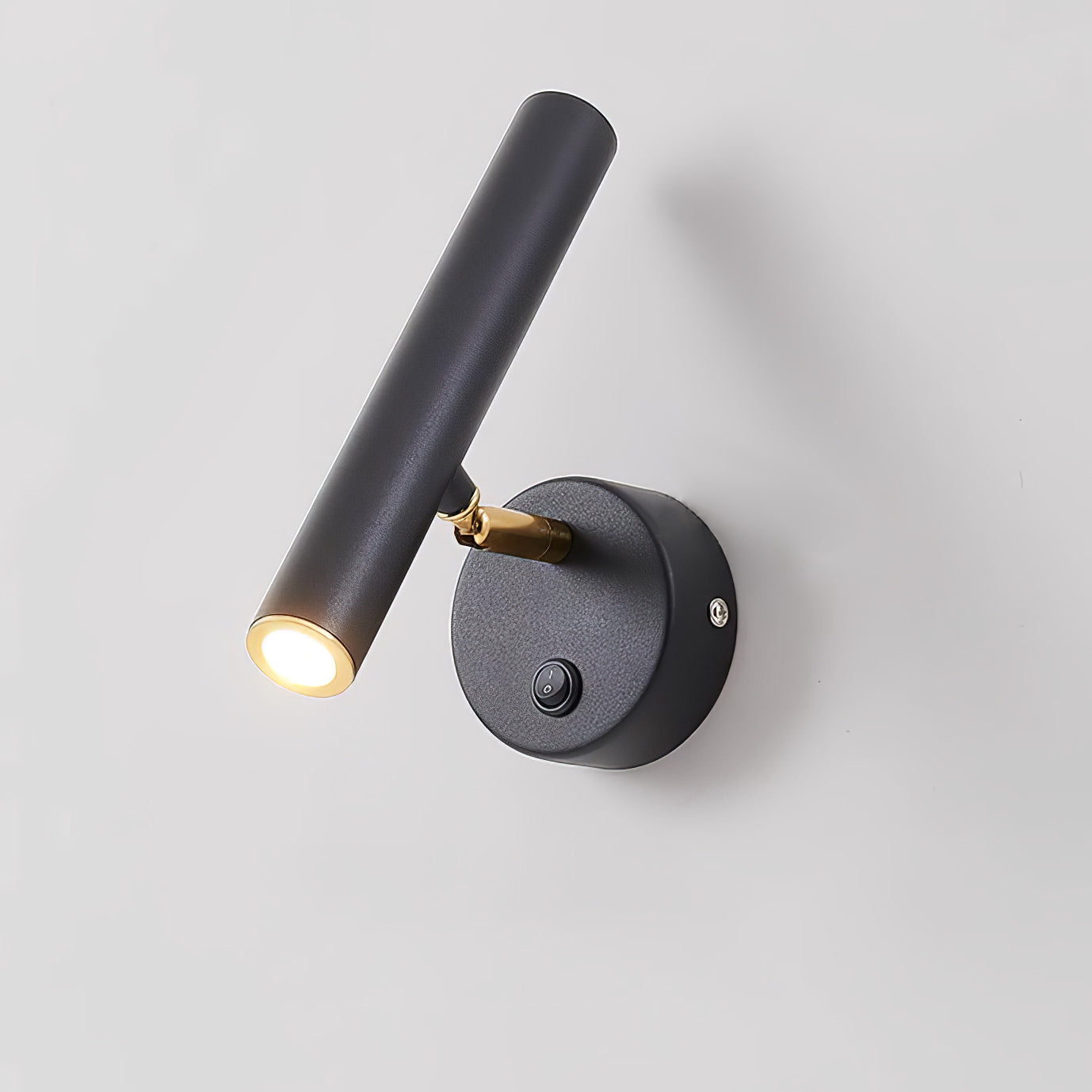 Close angled view of the black cylindrical head and illuminated opening beside the round plate switch