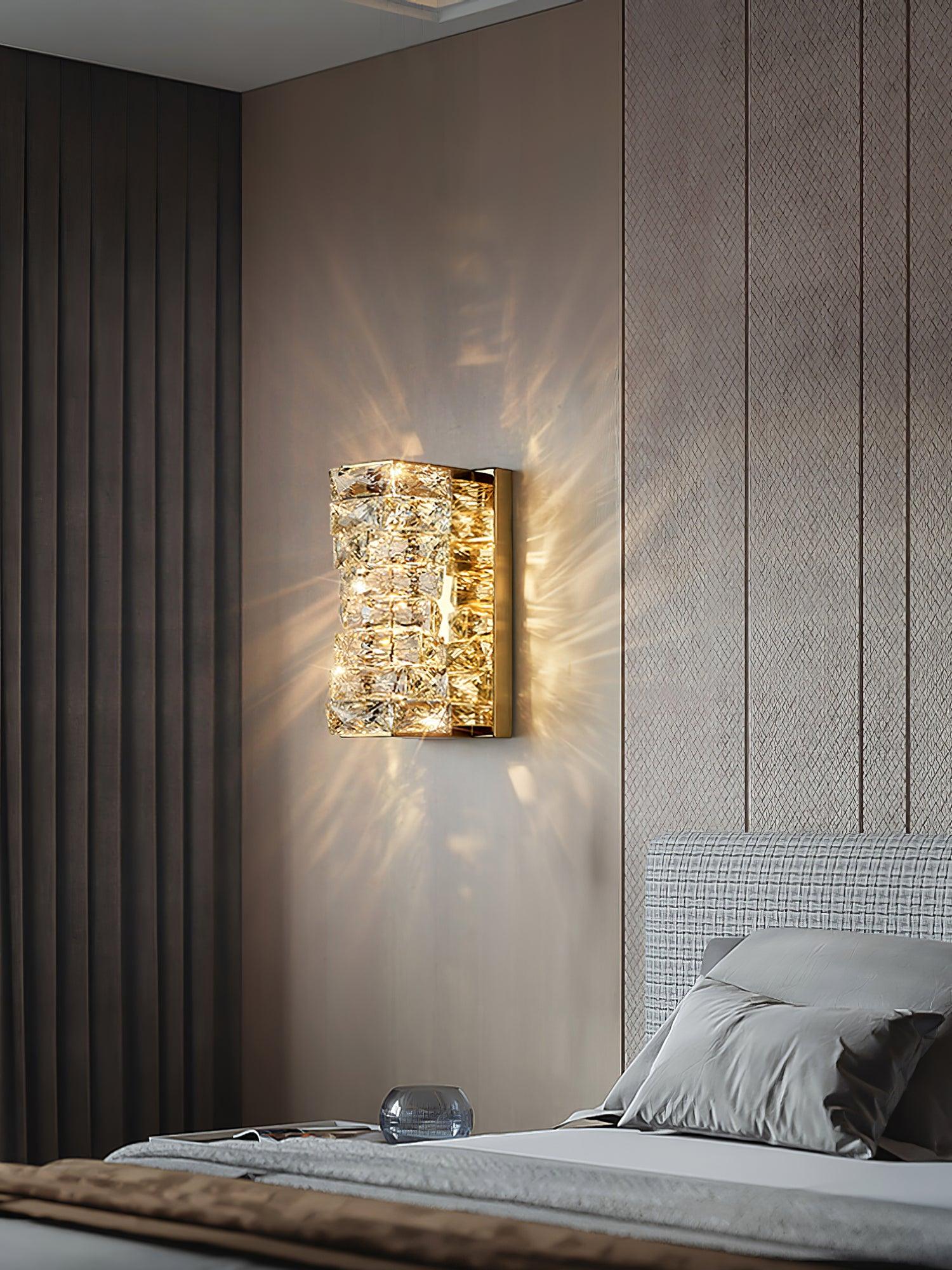 Short crystal wall light beside a bed
