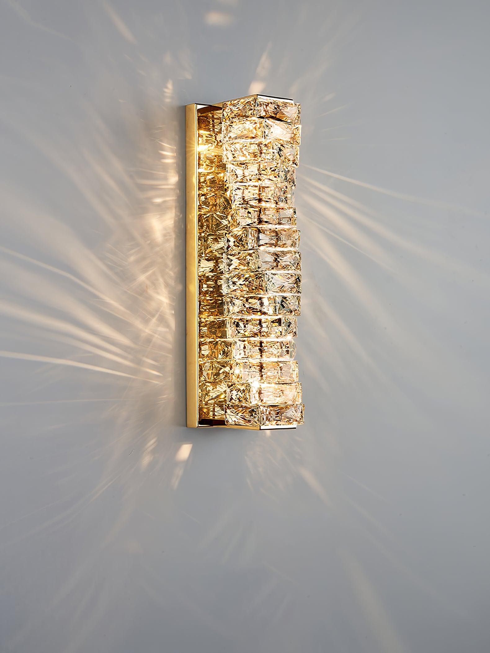 Gold layered crystal sconce against a pale wall